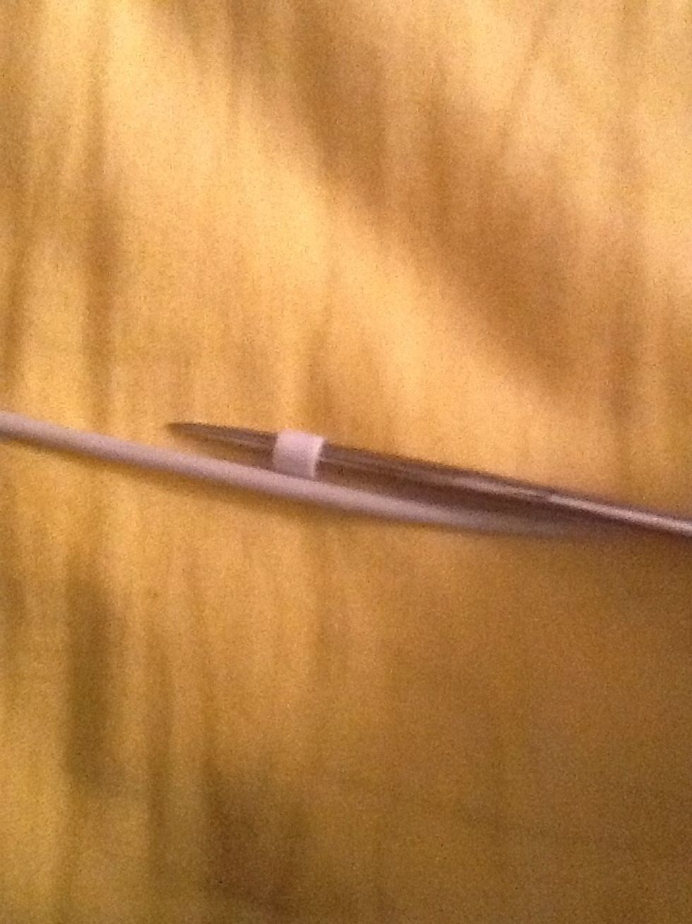 Place the cut of the bead right on the cord, and slide it off the scissors, and onto the cord.