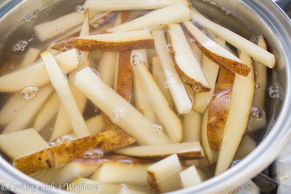 Place the cut potatoes into a large pot and fill the pot with water until it covers all the potatoes. Turn on the heat to high and cook the potatoes until the water boils.
