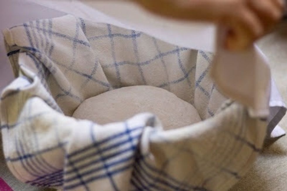Place the dishcloth and the dough in a tall bowl. This helps things keep their shape. Cover the bowl loosely and let it rise again for another 2 hours.