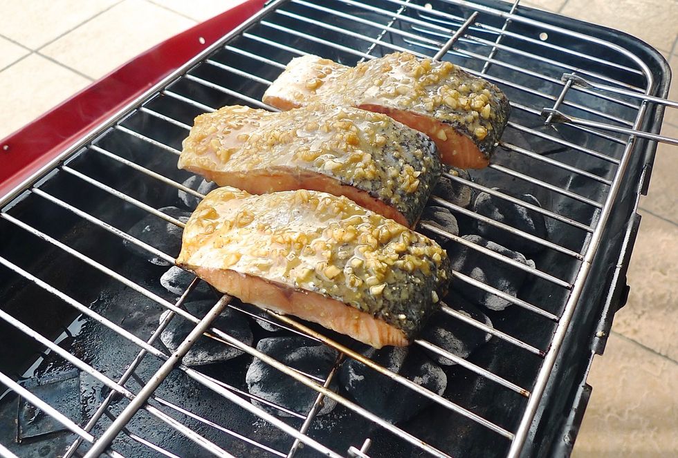 Place the drained salmon fillets SKIN-SIDE UP on the grill grate directly above the medium coals to cook over medium heat.