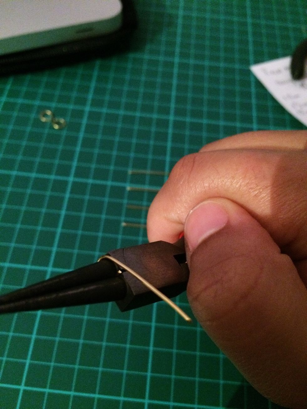 Place the end of the wire in between the round nose pliers on the largest part of the pliers and wrap it all the way around until it creates a loop.