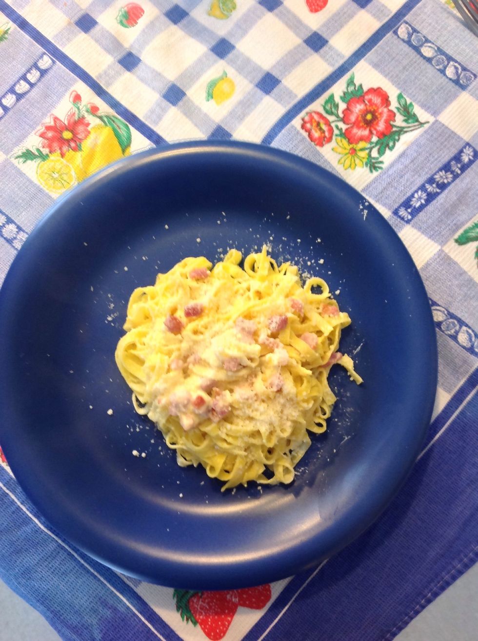 Place the fettuccine with some Parmesan cheese on the plate. Buon appettito!