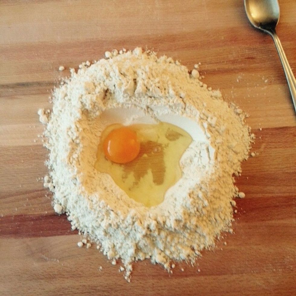Place the flour on a surface leaving a pit in the middle. Break the egg in