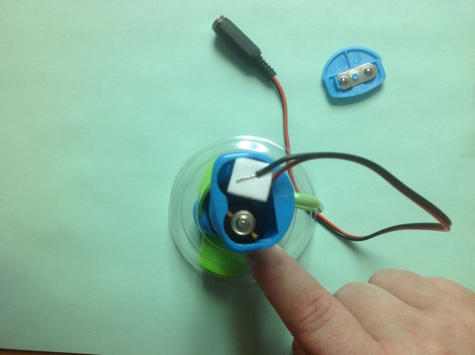 Place the foam dot on one battery (does not matter which one nor does it matter which color wire).
