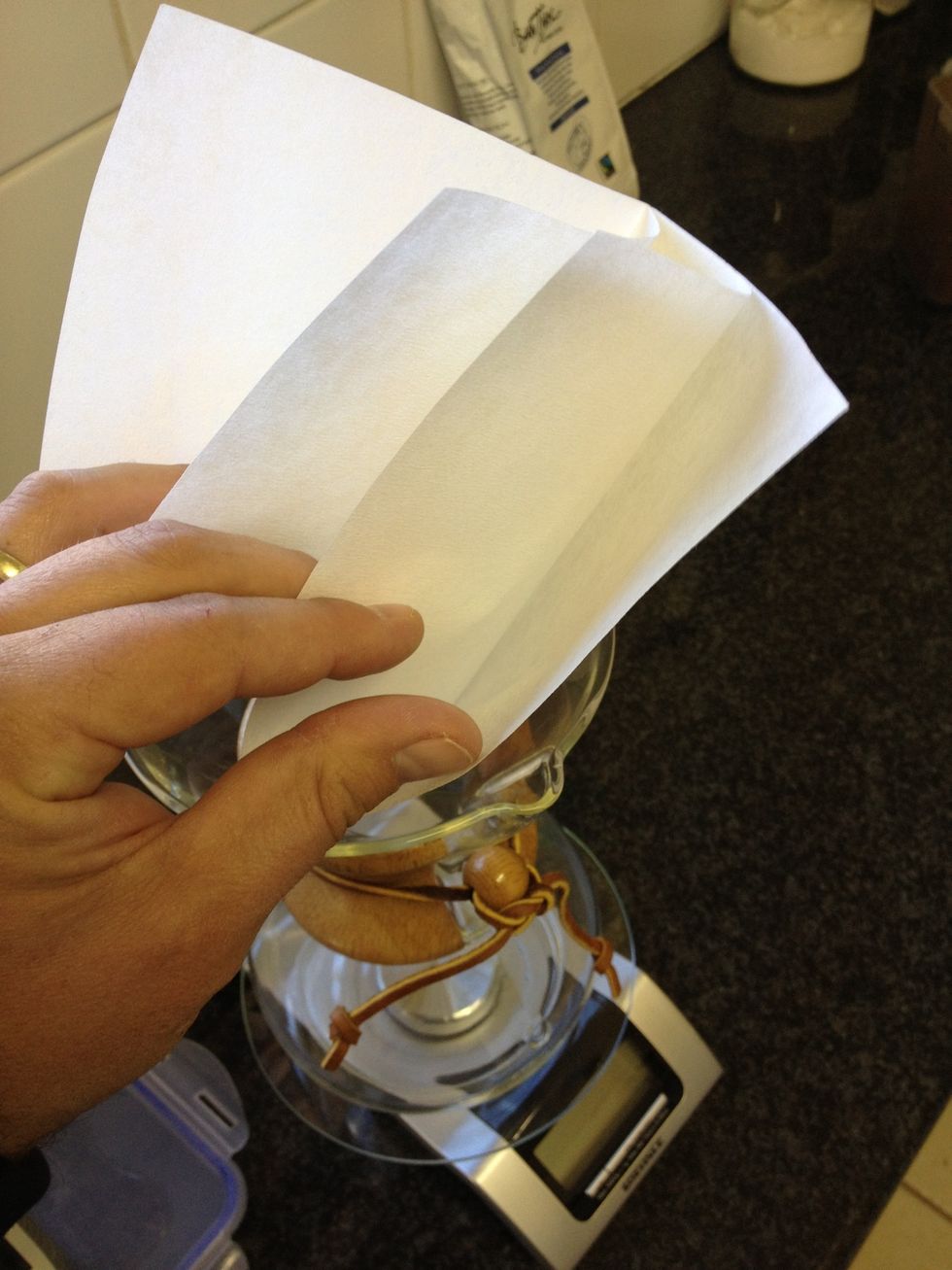 Place the four layered, square, Chemex filter paper in the Chemex by dividing the layers as follows: 3 layers spout side and 1 layer against the back of the carafe.