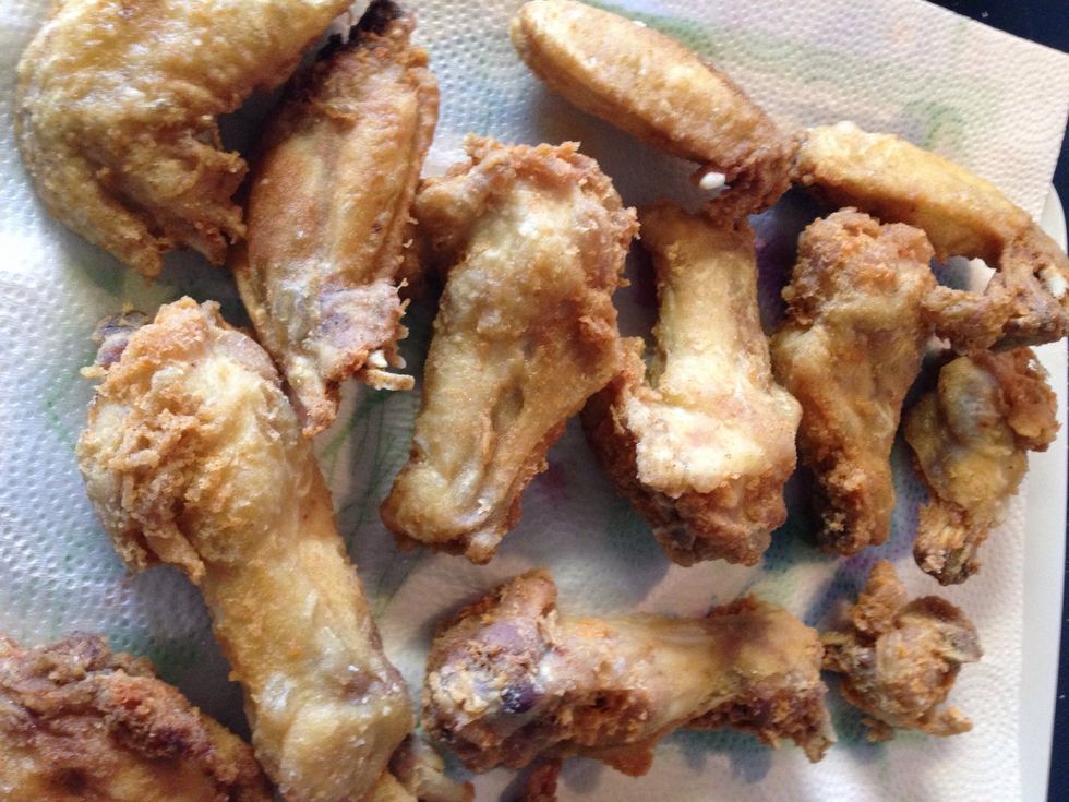 Place the fried wings on paper towel to absorb all the oil