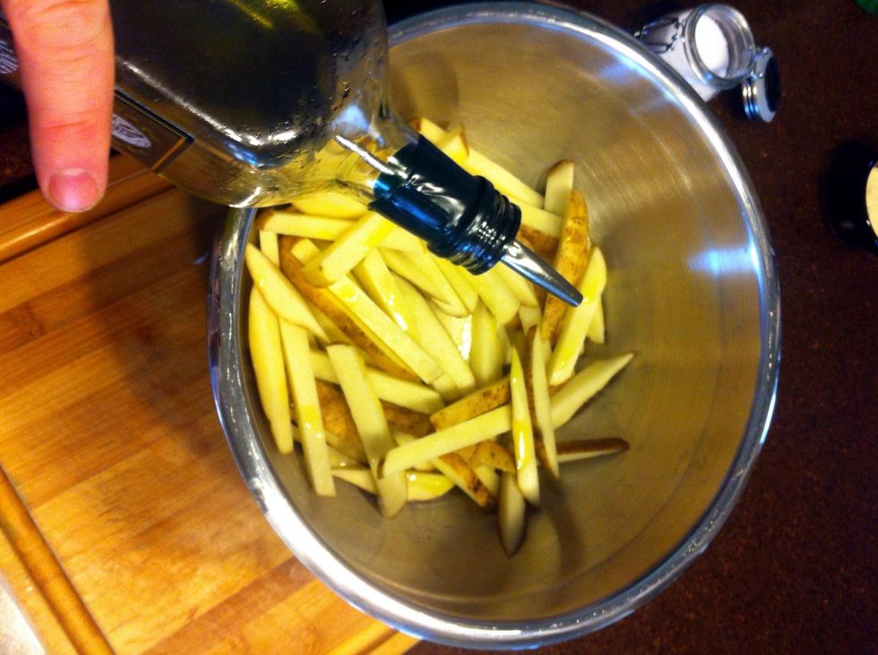 Place the fries in a large bowl, drizzle with olive oil, and add a pinch or two of salt and a little fresh ground black pepper. Toss until the fries are well coated.