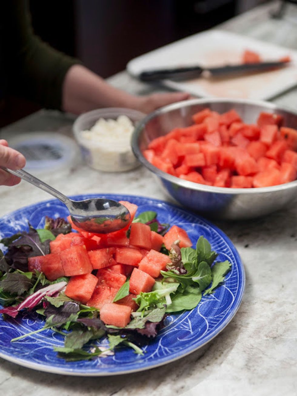 Place the greens on a platter, and top them with the watermelon cubes.