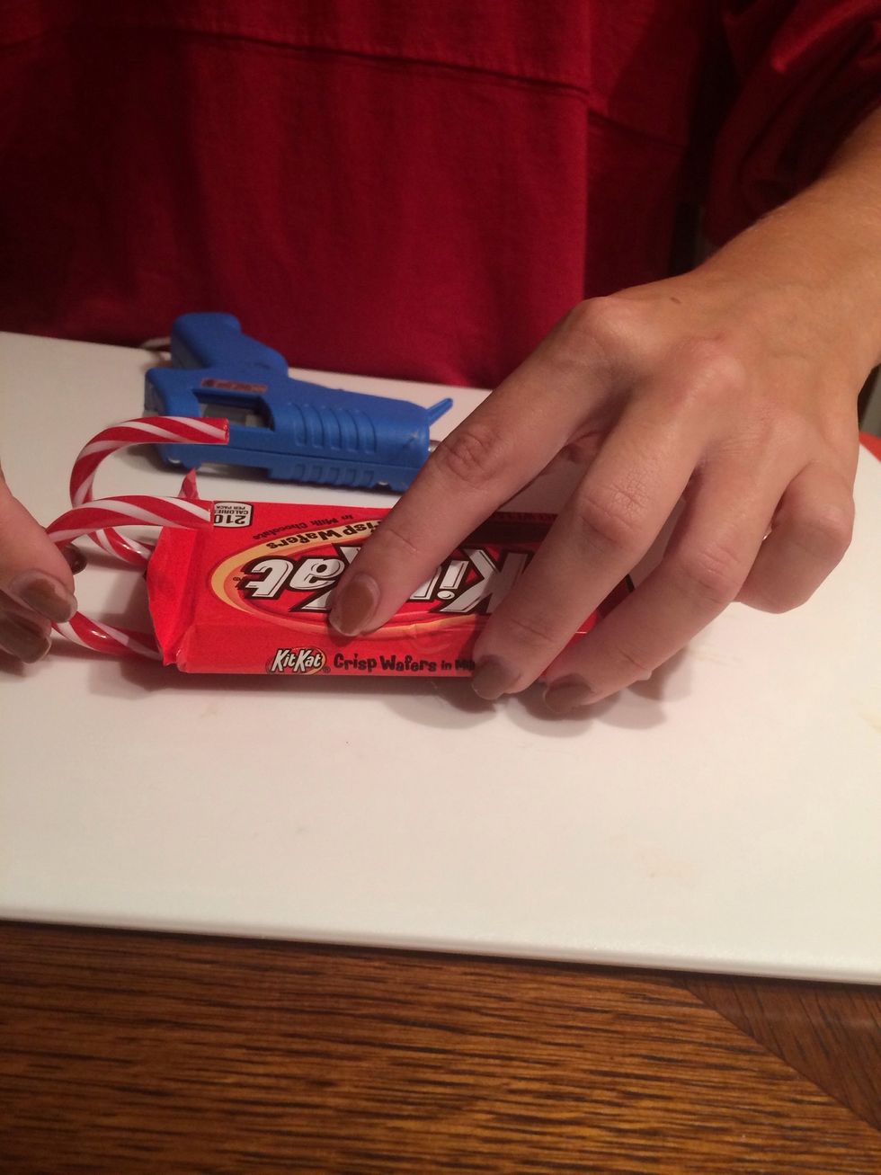 Place the KitKat bar on the candy canes and wait for the glue to dry.
