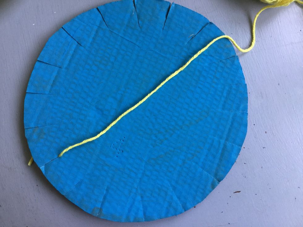 Place the knot behind one of the slits and pull the yarn through it.