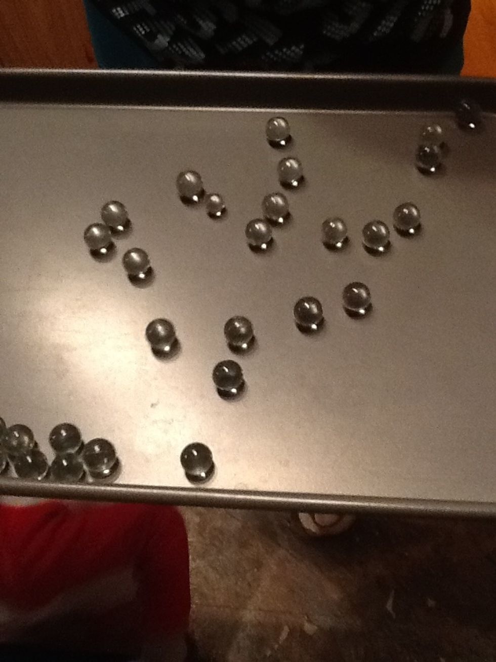 Place the marbles on a cookie sheet( or cake pan ), don't use fully colored toy marbles you can't see the cracks! use the kind you would fill vases with!