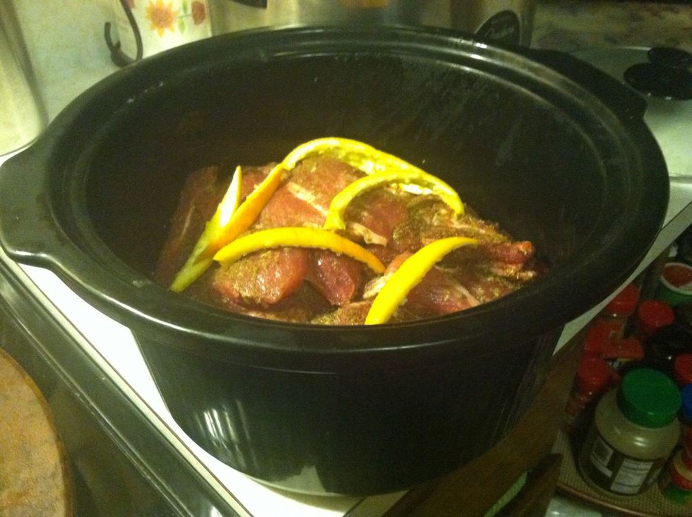 Place the orange peel and onion on top of the pork.