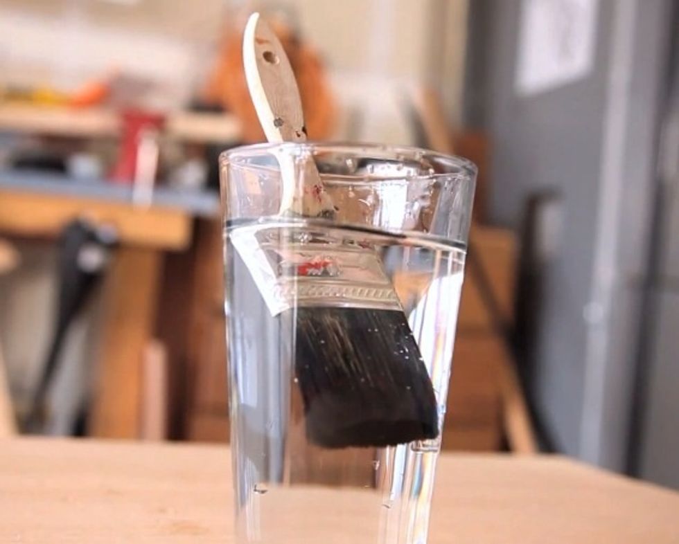 Place the paintbrush in the water.