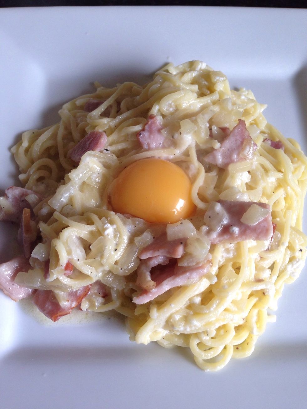 Place the pasta on the plates in a shape of little volcano with a crater on top. Put the yolk into that crater.