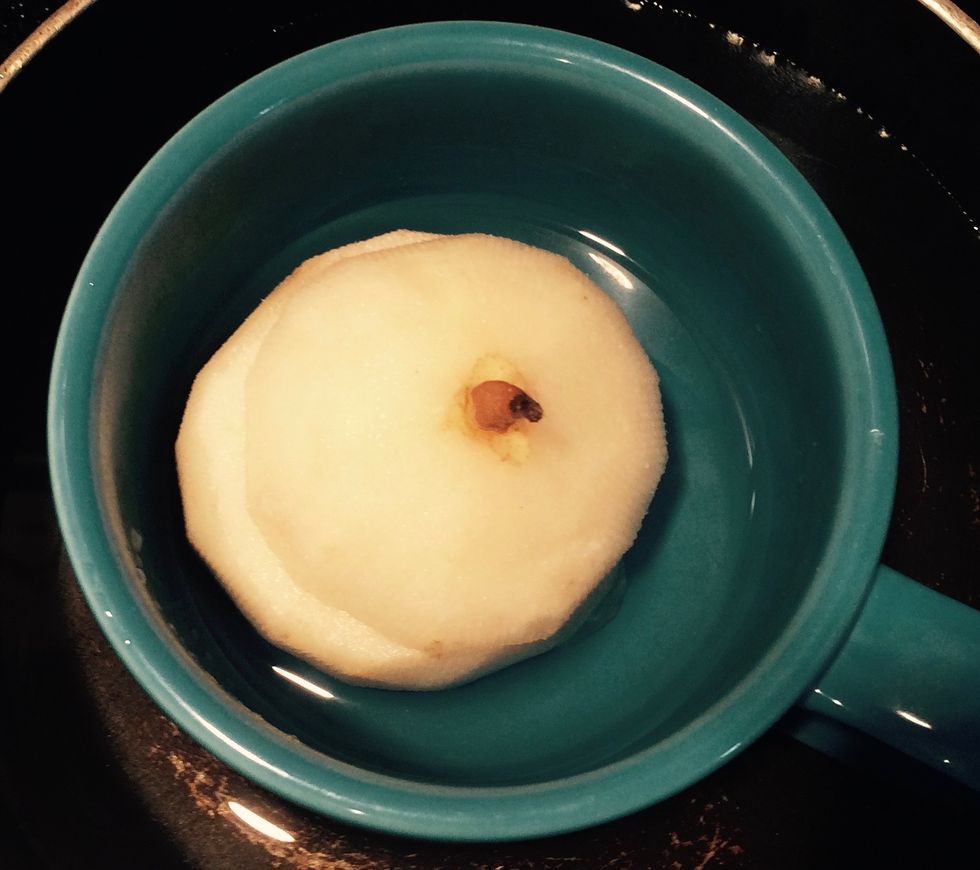 Place the pear in the cup/mug. Fill the cup/mug about 1/3 full with boiled (hot) water. Place the cup/mug in a sauce pan. Fill the sauce pan with enough water to cover 2/3 of the cup/mug.
