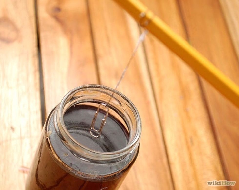 Place the pencil over the jar and allow the string to dangle into the solution. Don't let the string settle on the bottom or sides of the glass.
