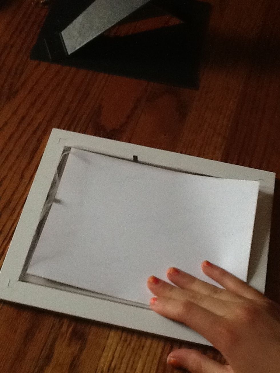 Place the picture over the plastic cover. Make sure the edges of the mesh fabric are sticking out of the sides of the frame.