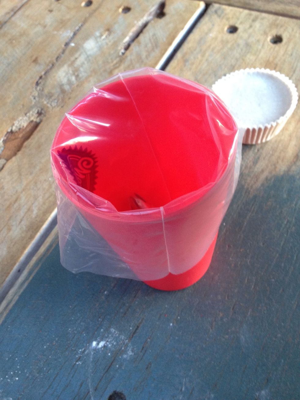 Place the piping bag tip-first into a large plastic cup. This makes it easier and less messy to fill the bag with the plaster mix.