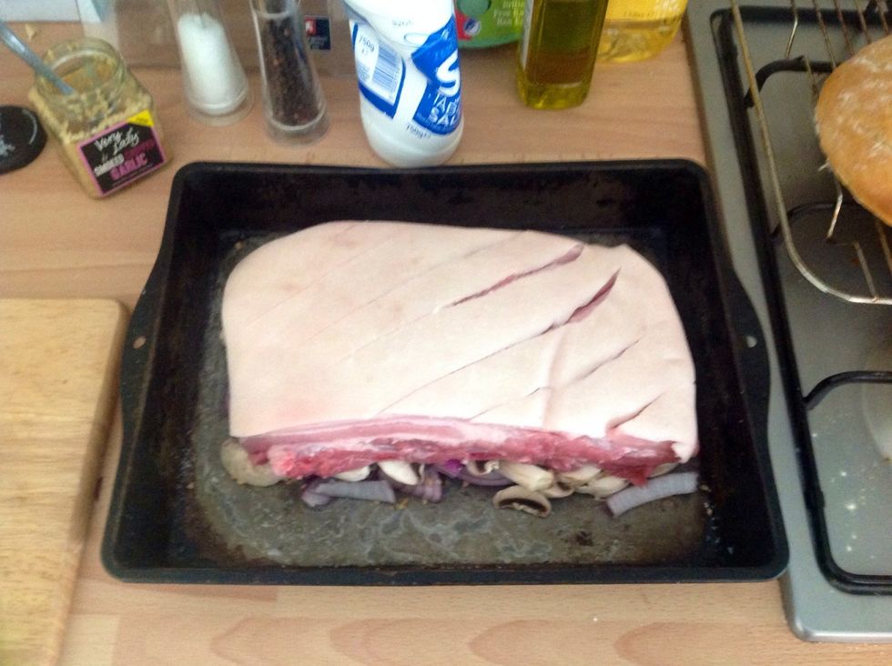Place the pork on top and pat the fat dry with kitchen towel, then using your hand rub the salt into the scored fat using as much as you like depending on how salty you like crackling