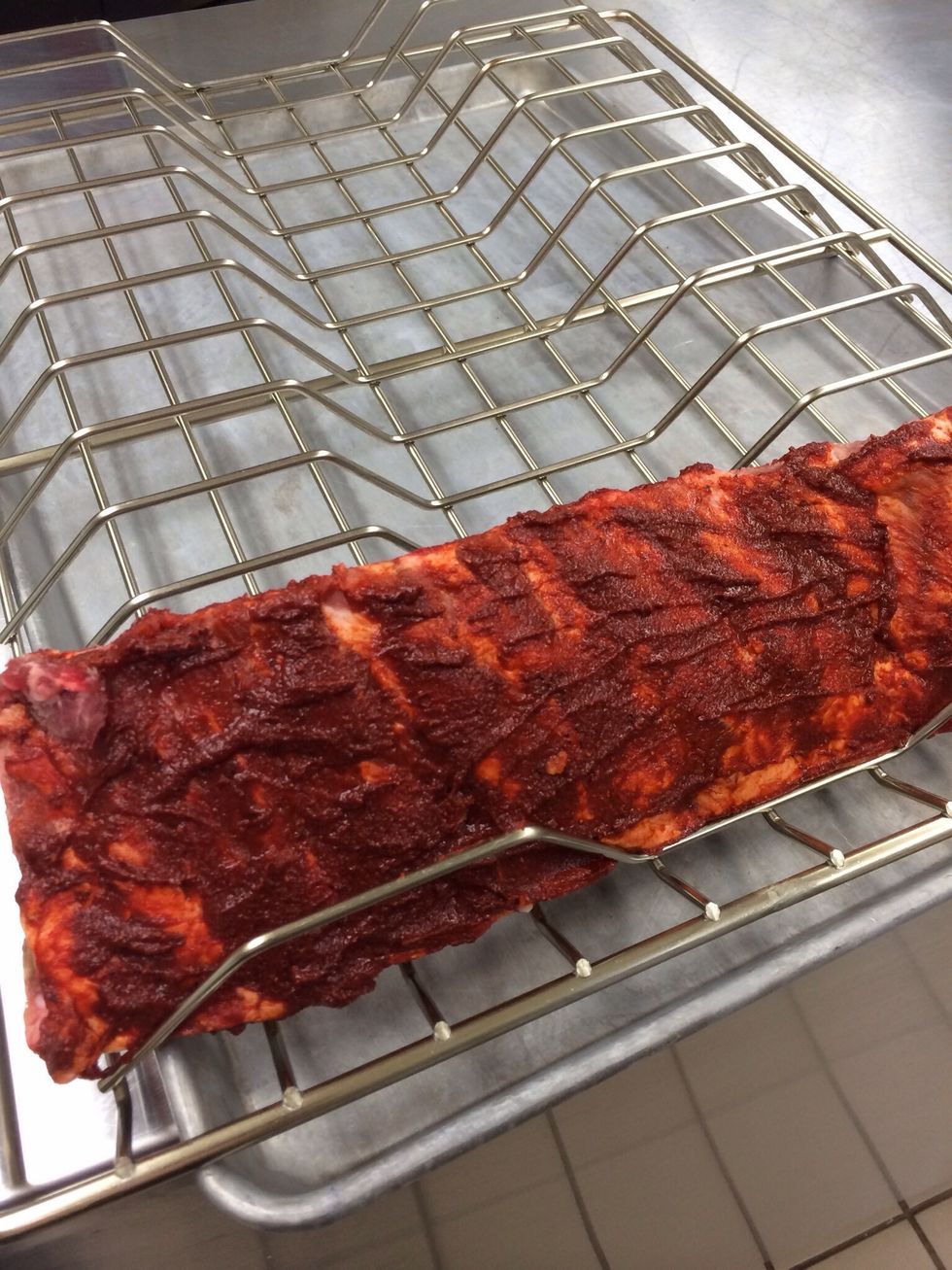 Place the prepped ribs into the rib rack and place into the smoker unit starting in the top slot. Securely close the door of the unit.