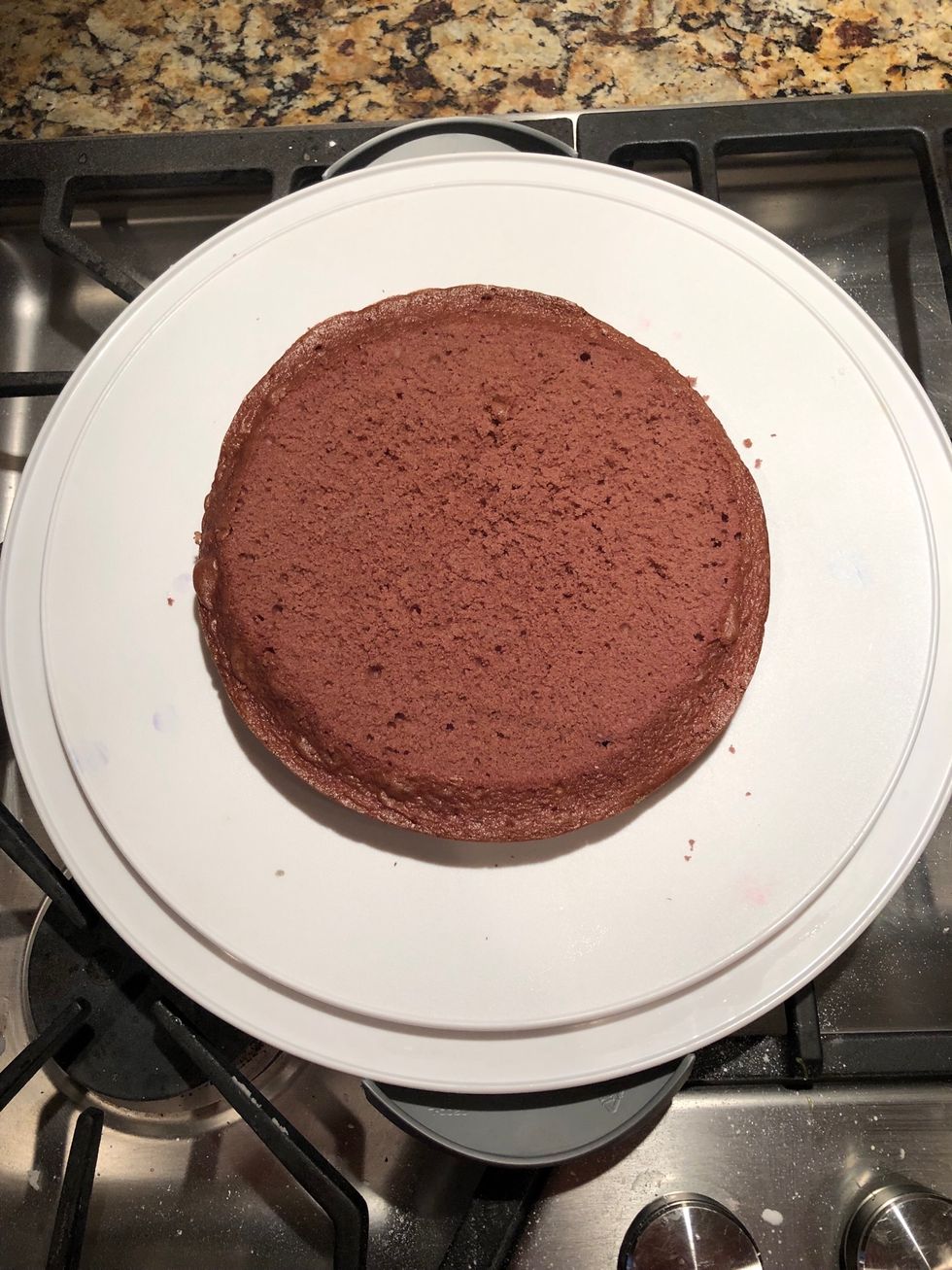 Place the purple layer of cake in the center of a plate.