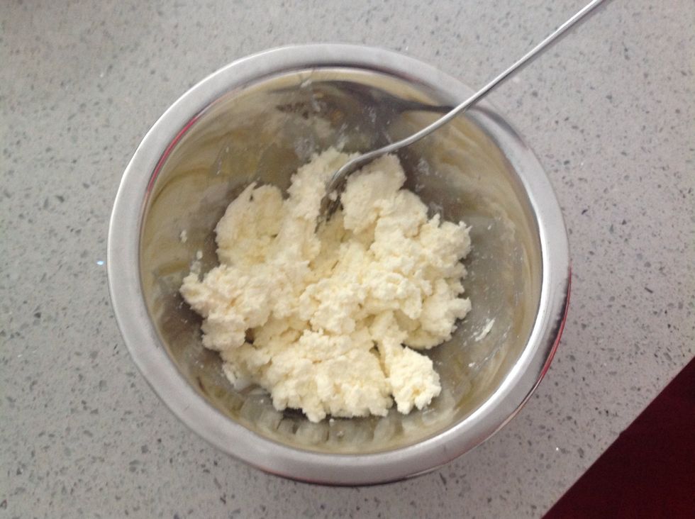 Place the ricotta cheese into a mixing bowl and mash lightly.