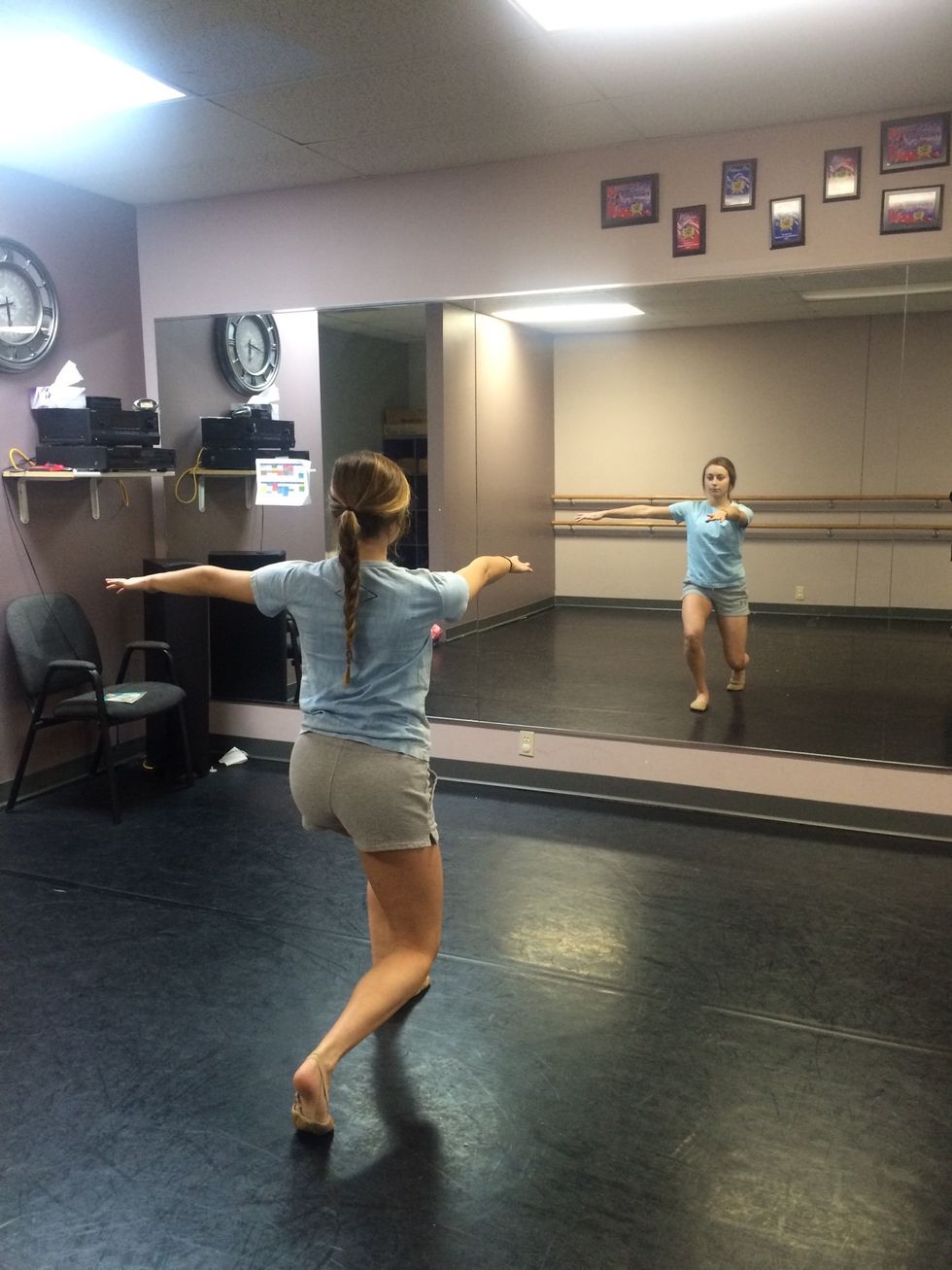 Place the right foot behind you and bend your knees. Make an "L" shape with your arms by leaving your left arm straight out to the side and moving your right arm directly in front of you.