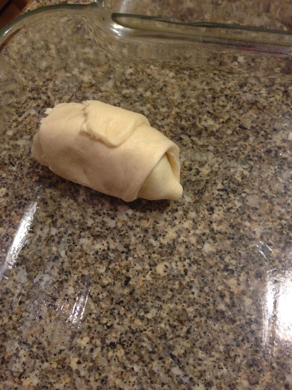 Place the rolled up apple in the pan