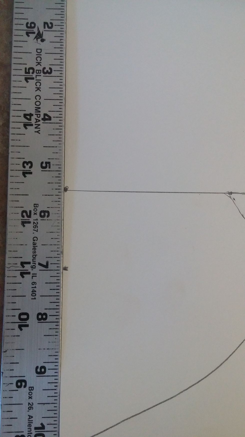 Place the ruler along the left side of the paper. Make a mark at the 7 inch mark down.