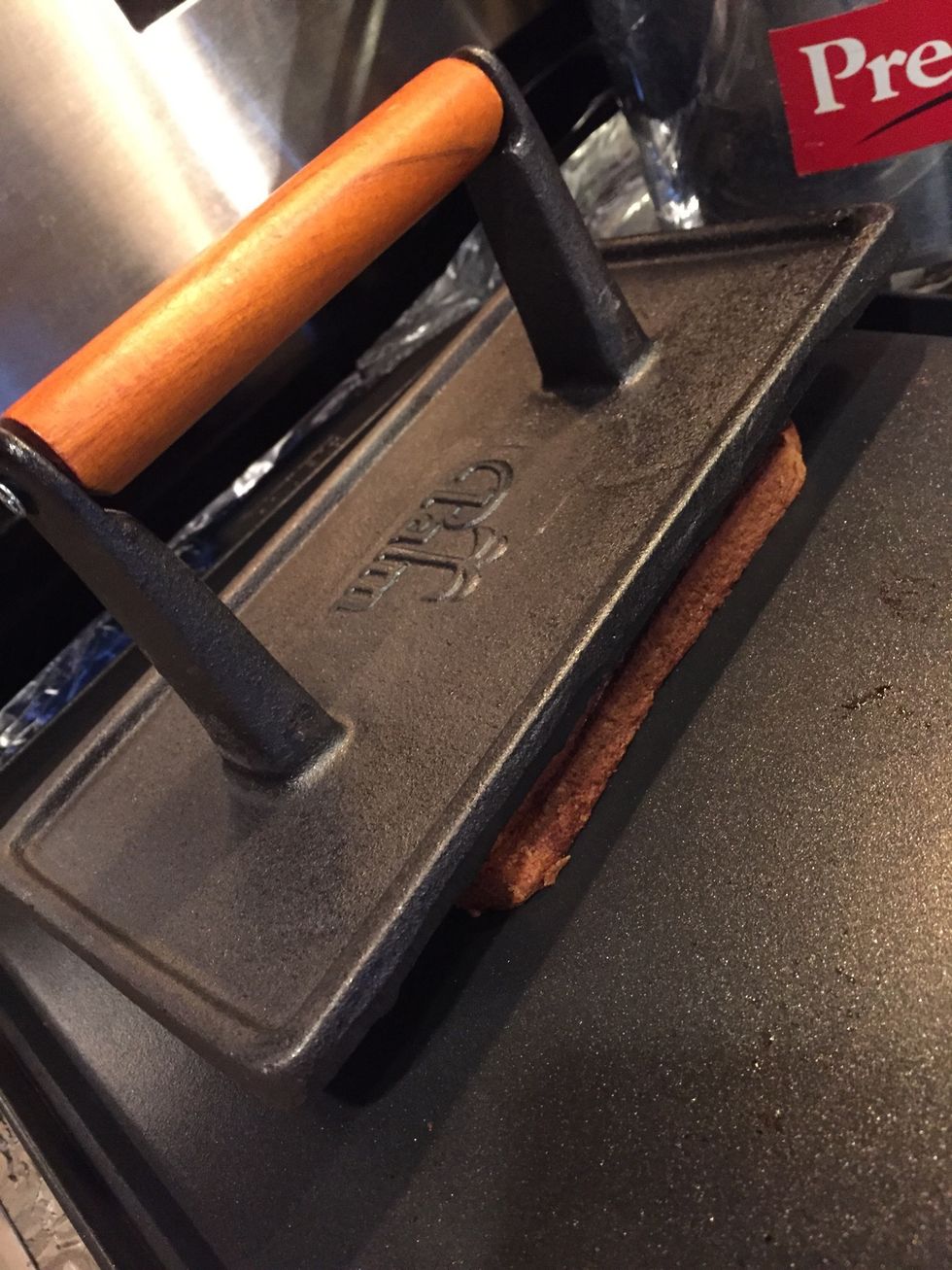Place the second slice of toasted bread (brown side in). Put a little butter on the grill and place the sandwich on it. Press down with a grill press if you have one.