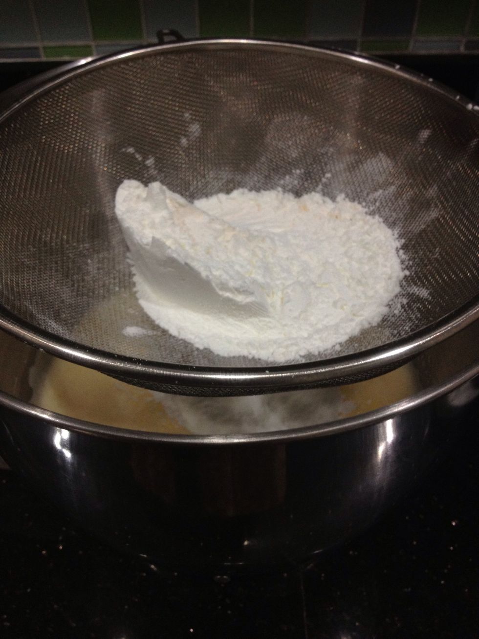 Place the sieve over the bowl of the beaten egg and sugar, and sift the flour mixture again.