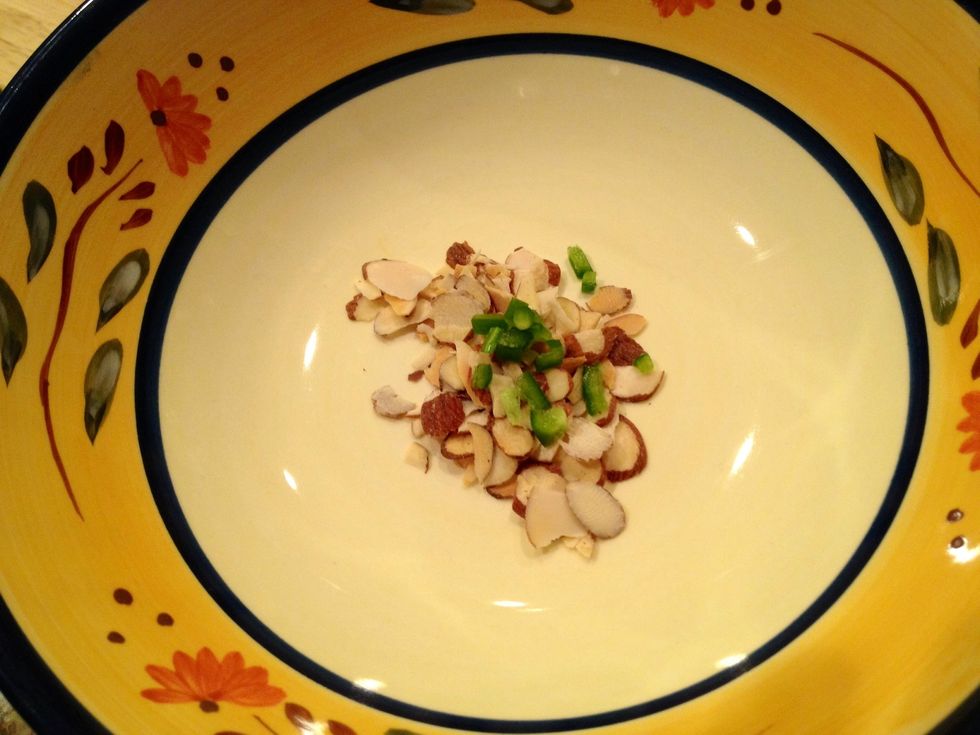 Place the slivered Almonds and the small diced Jalape\u00f1o Peppers in the bottom of a bowl.