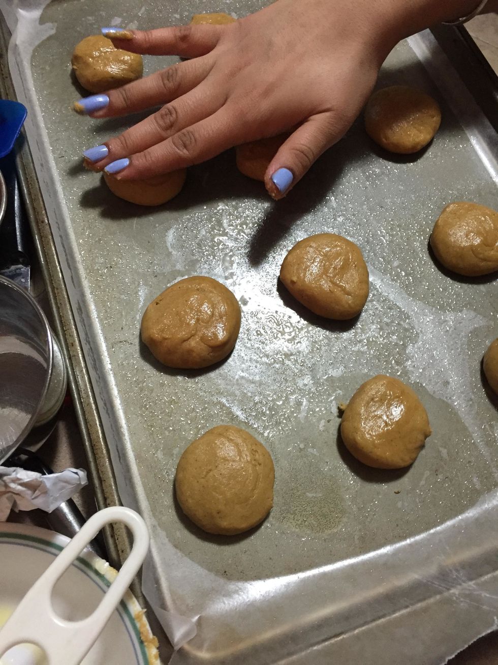 Place the small balls on the greased cookie sheet and slightly flatten on top.