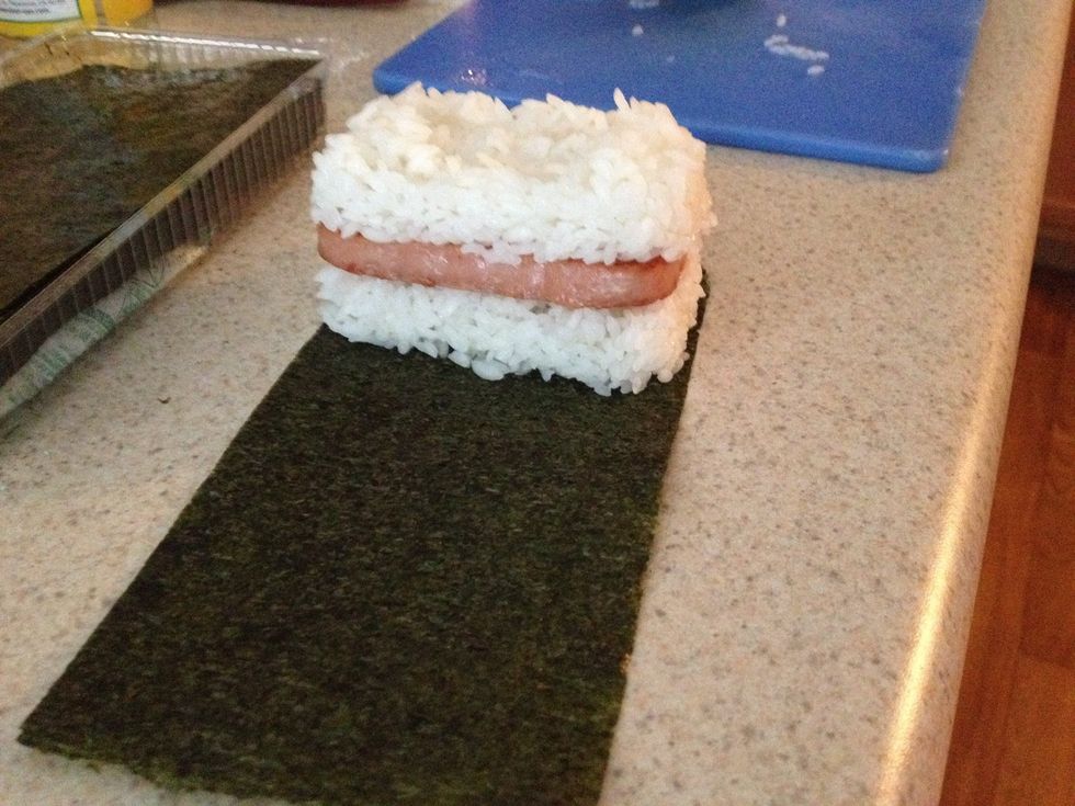 Place the spam sandwich on the nori. I messed up and placed it at the end. It's easier if you put it in the middle and wrap both sides.