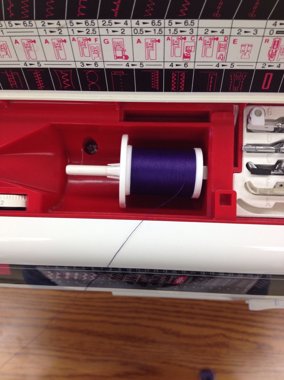 Place the spool of thread in the top of the machine on the spool pin. Place the spool holder on the end.