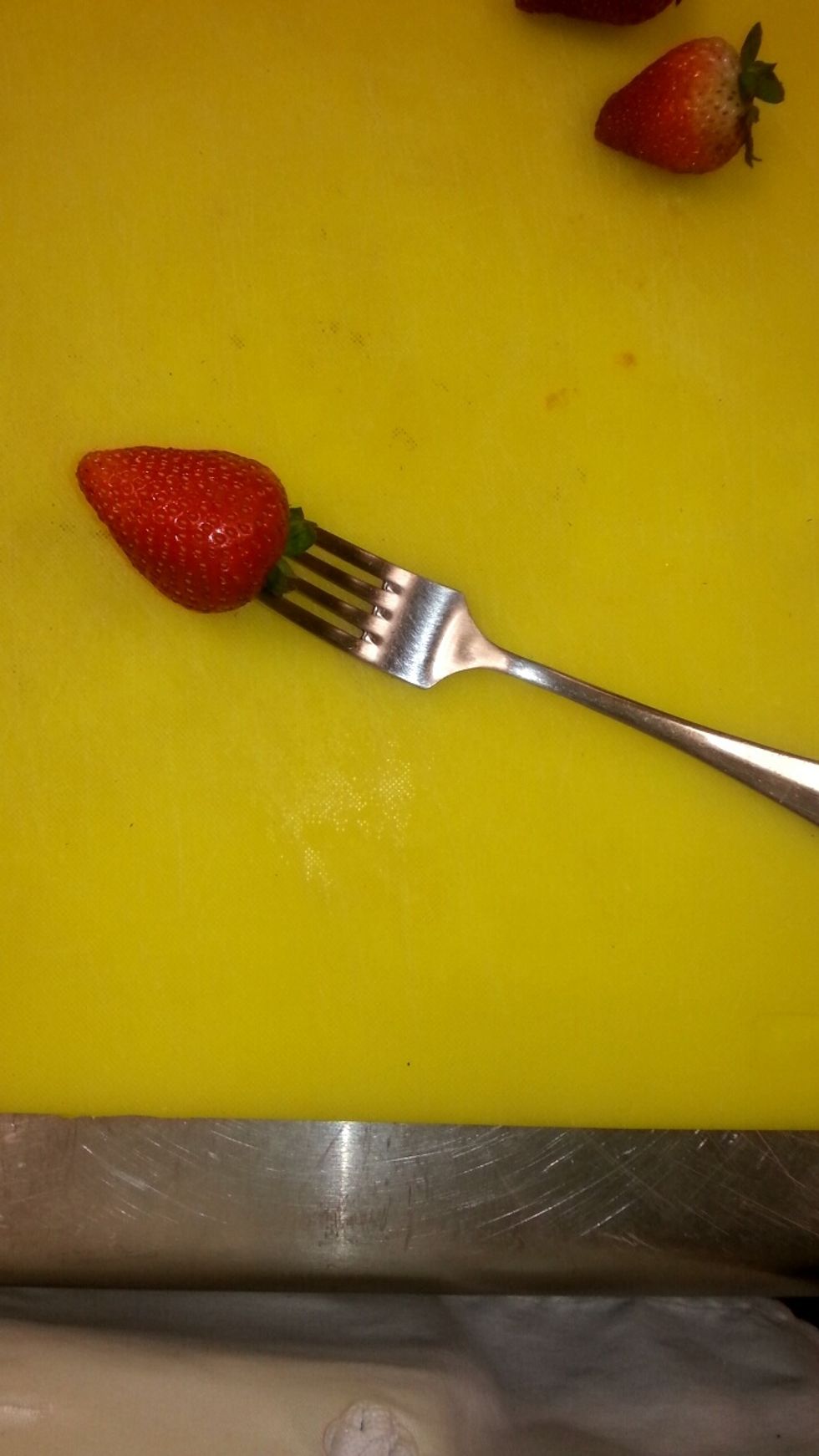 Place the strawberry onto the fork, (not all the way through)