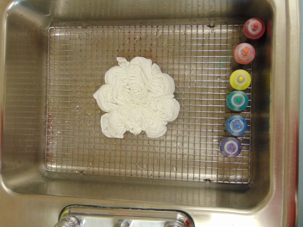 Place the t-shirt on the wire rack in the sink. The rack doesn't have to fit in the sink it just needs to keep the shirt off the bottom of the sink and pools of dye