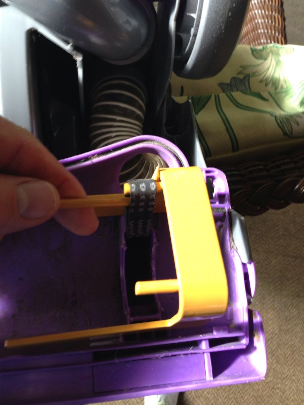 Place the tool with the prongs facing toward the center of the vac. Pull the belt using the hooked tool. Pull like crazy until you can slip it on to the top prong. Take a breather.