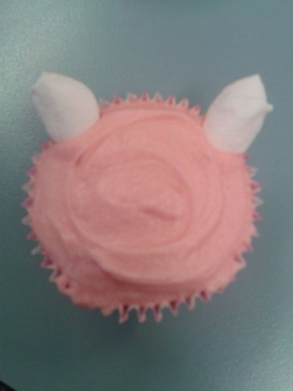 Place the top of the marshmallows that you cut on top of the cupcakes for the ears.