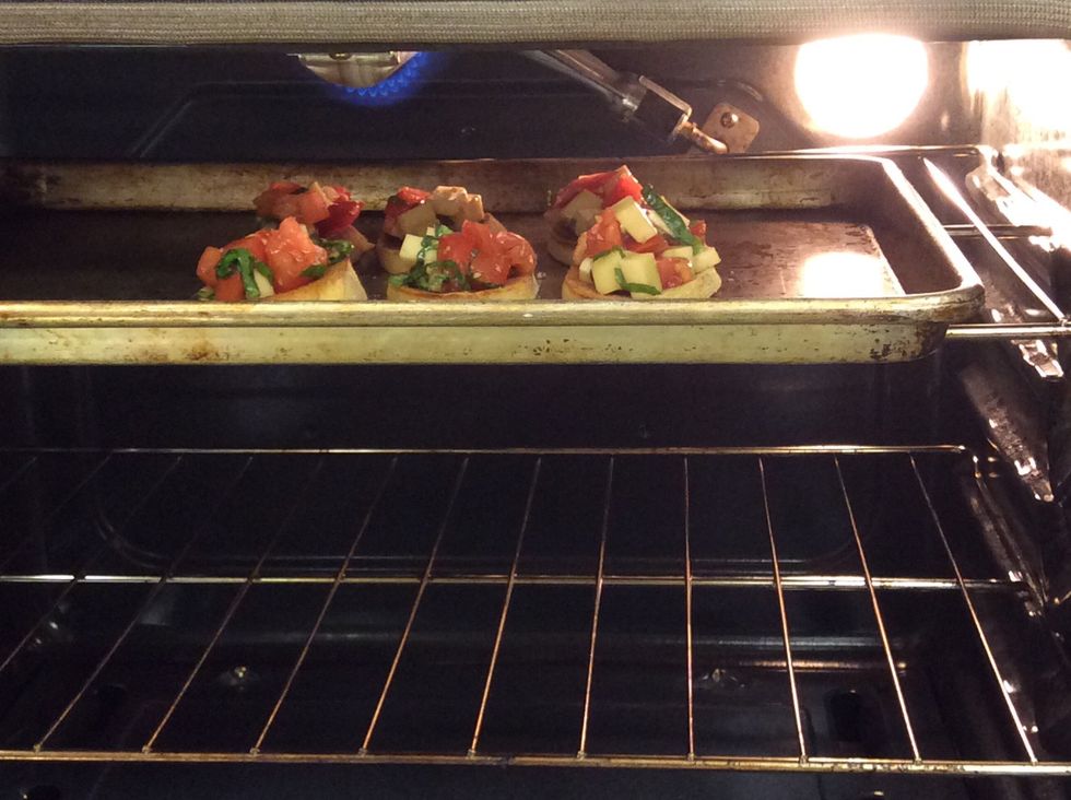 Place the topped bruschetta in the oven to broil. You will broil it until the cheese is nice and melty.