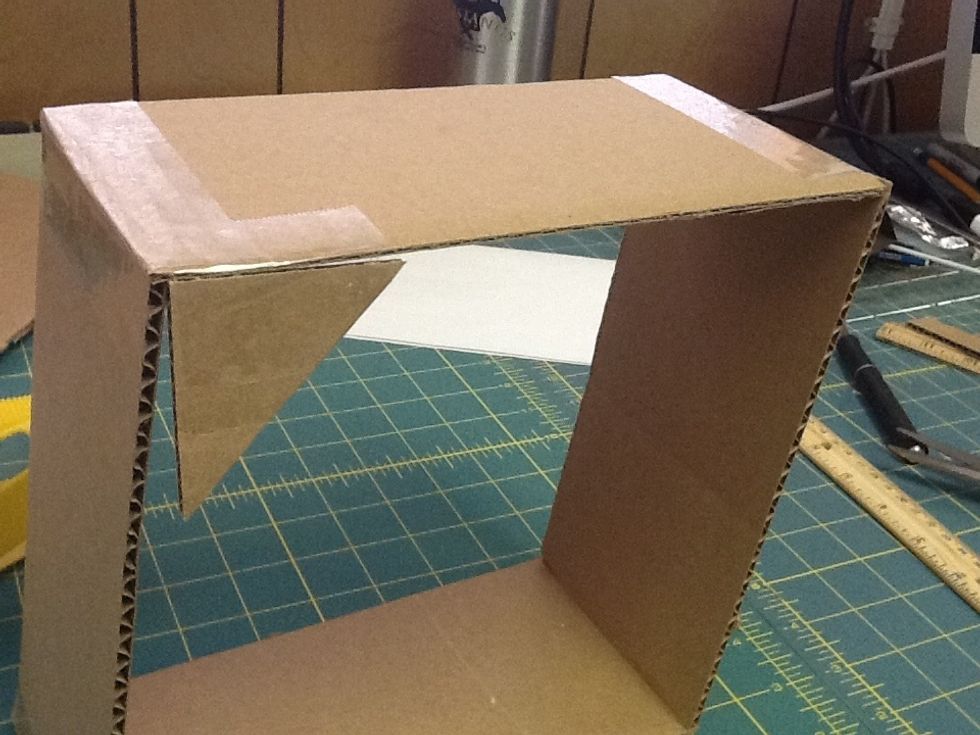 Place the triangle in one corner of your frame, making sure you fold the exposed tape over onto the side. Take advantage of the right angle in the triangle! Place the triangle directly in the corner.