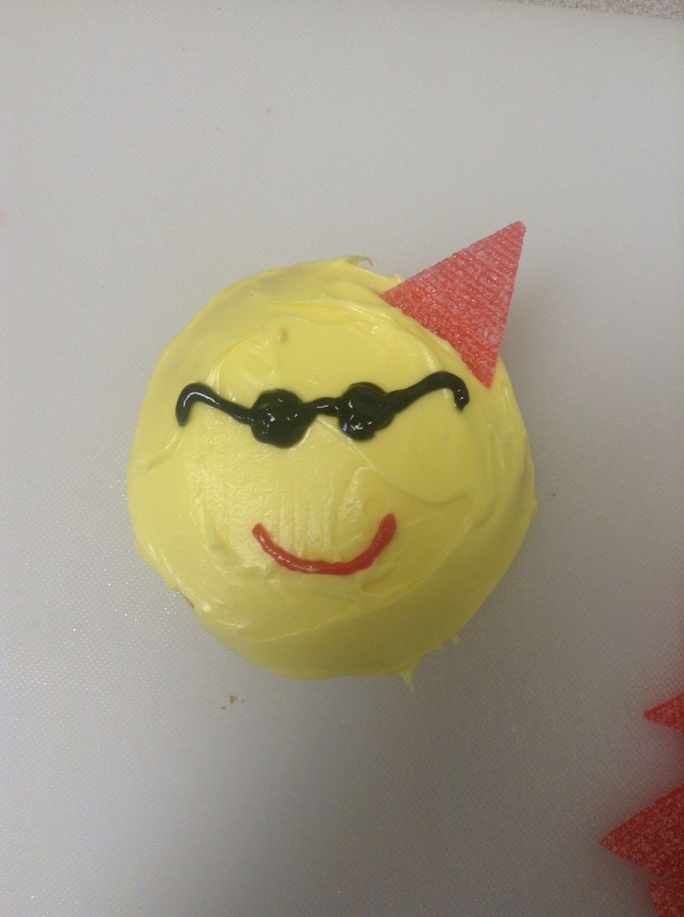 Place the triangular sour straps around the circumference of the cupcake.