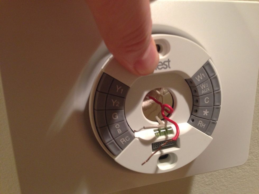 Place the trim plate and base on the wall and thread the wires through the center of them.