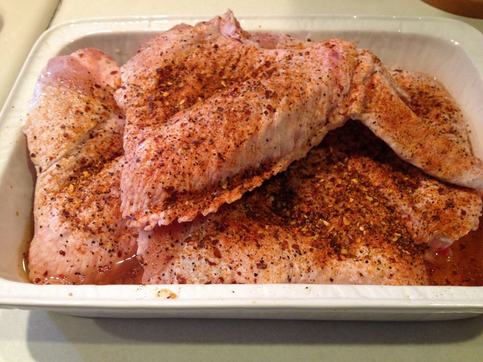 Place the turkey wings in a cooking dish then pour about 2 cups of apple cider vinegar over the turkey wings. Then season the turkey wings on both sides.