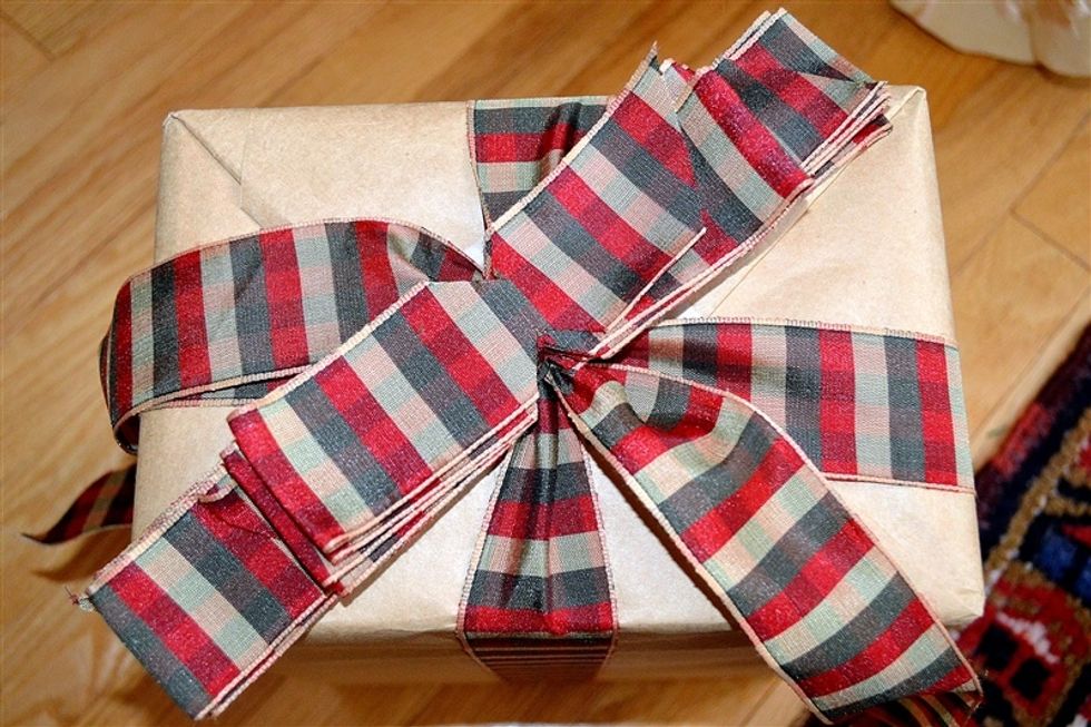 Place the two accordion folded sections of ribbon on top of the knotted ribbon on the top of the package.