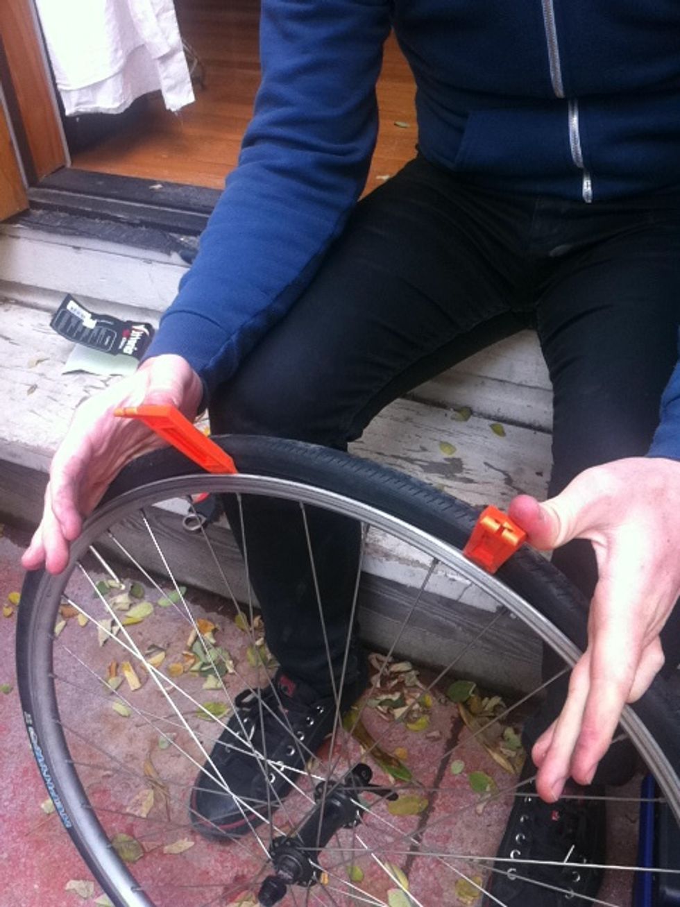 place the two tire levers in between the tire and the rim