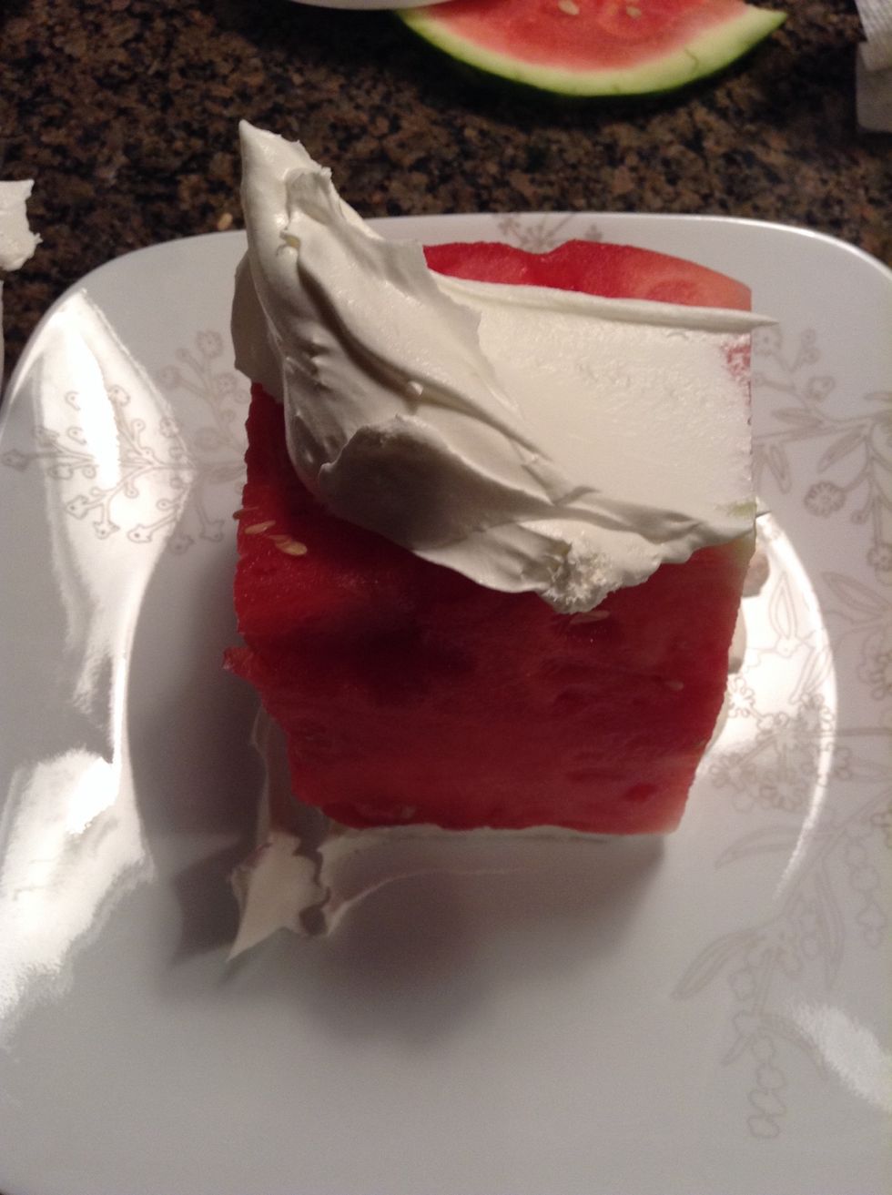 Place the watermelon cube on top of the bit of cool whip on the plate. Then put another dollop of cool whip on top of the watermelon cube.