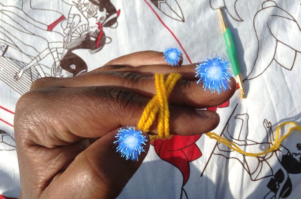 Place the working yarn across the tail end to form an X over your two fingers.