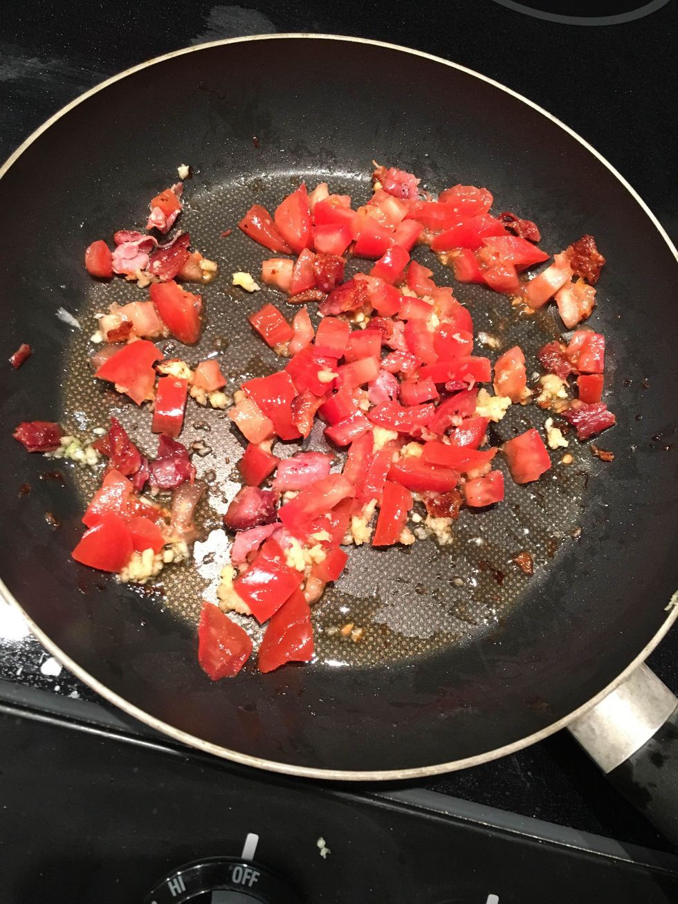 Place tomatoes, garlic, and bacon into pan with olive oil. Stir until done.