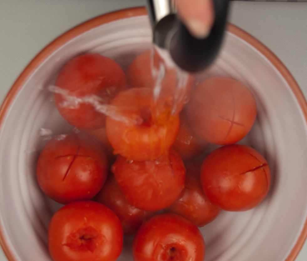 Place tomatoes in a large bowl or pan and cover them completely with boiling water.